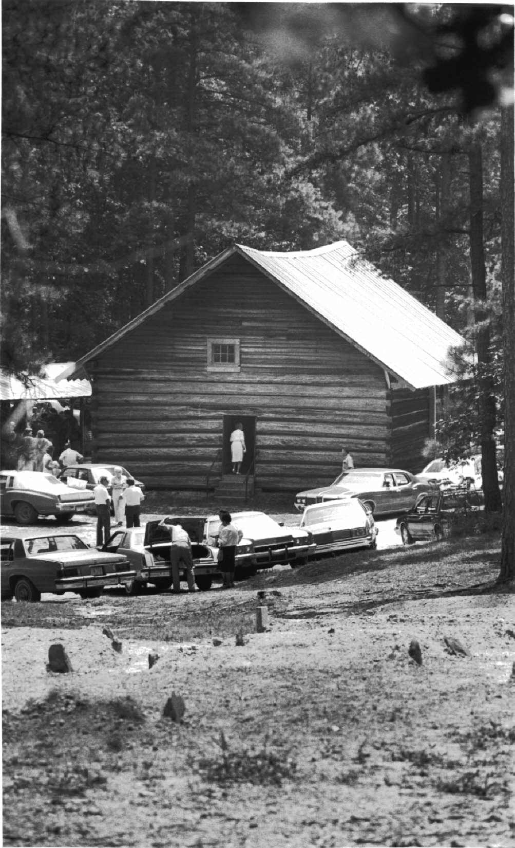 A gathering in the 1970s with the graveyard in the foreground, holding remains of many original settlers.